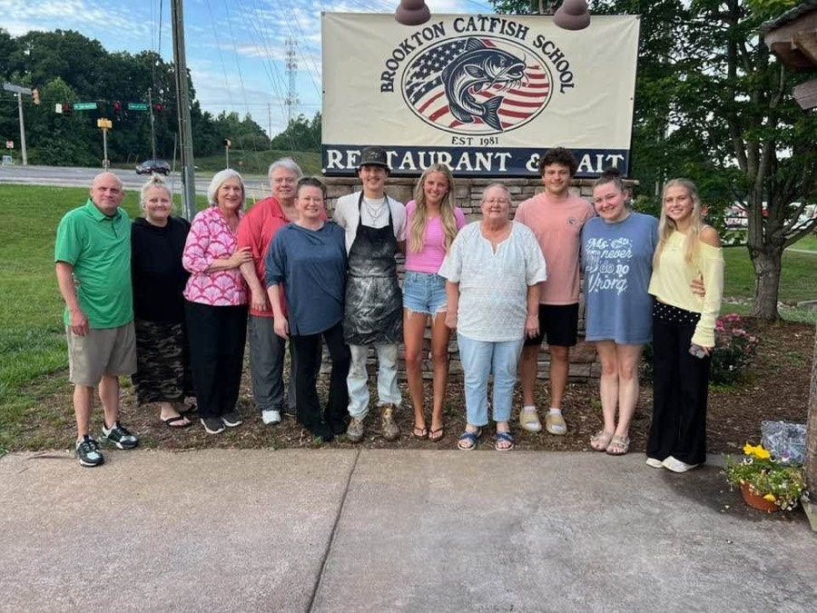 A group of customers gathered in front of the Brookton Catfish School sign