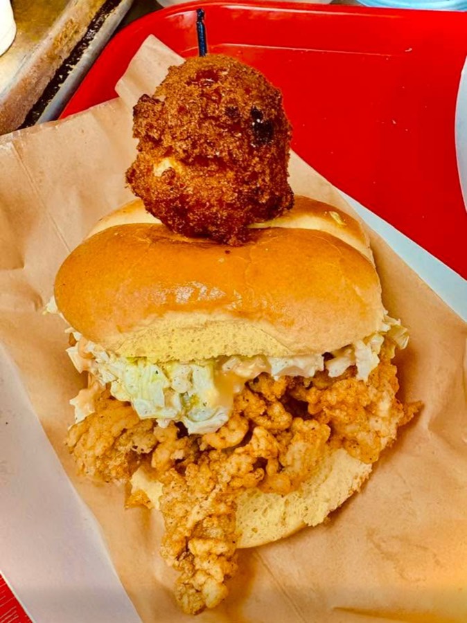 Fried oyster sandwich with a hushpuppy on top